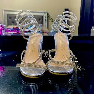 Shoes with silver broken feet, with straps and crystalline heel.